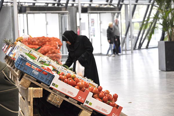 Grønthandlerens varer er stillet frem i Vollsmose Torv og en dame udvælger hvad hun vil købe