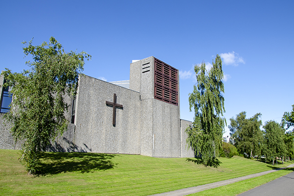 Facaden af Vollsmose Kirke med korset på betonvæggen