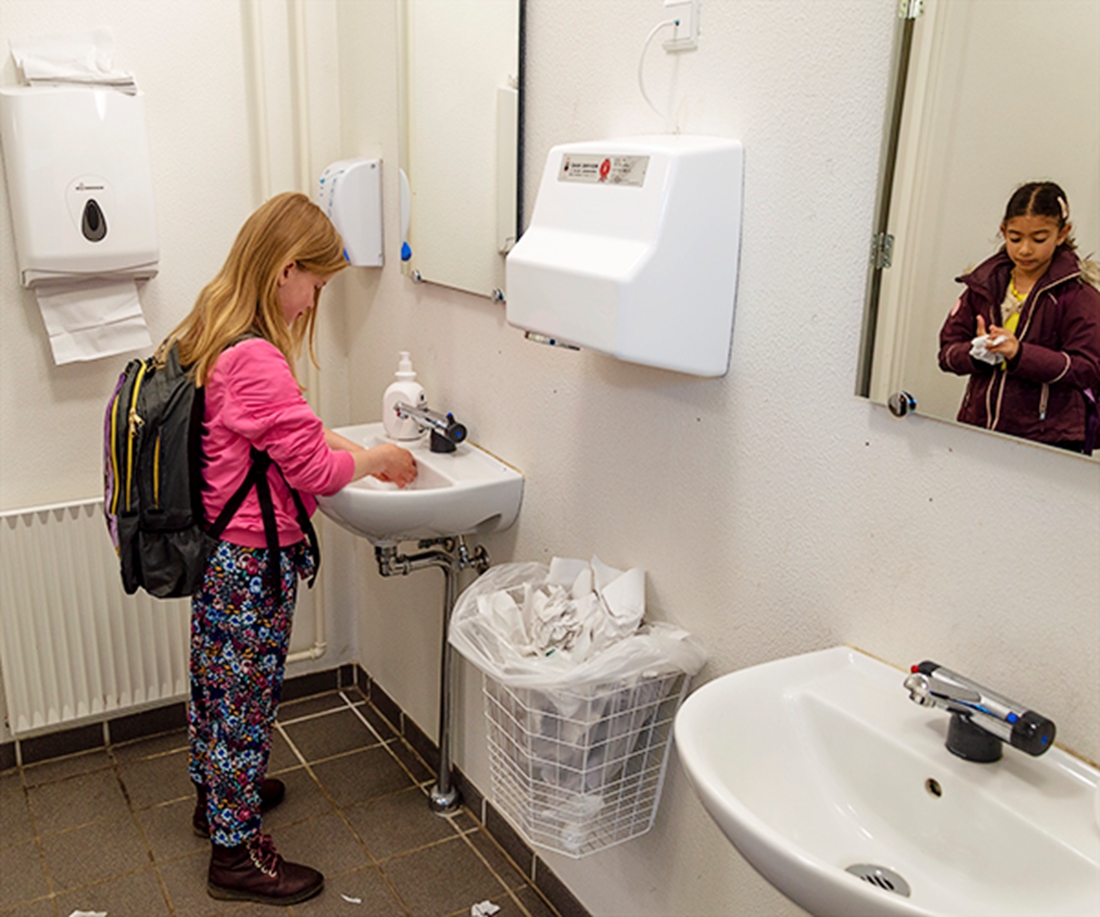 et par piger vasker fingrene på skoletoiletterne